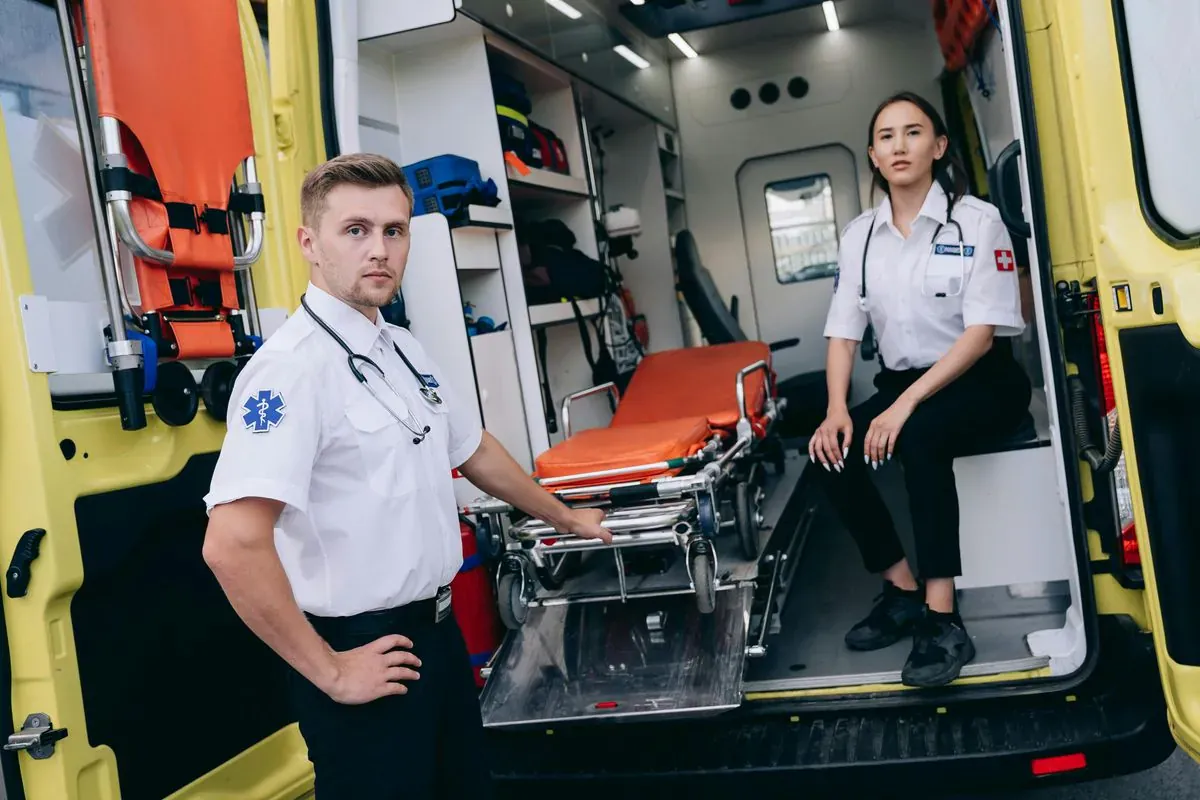 Paramedics preparing a stretcher beside an ambulance