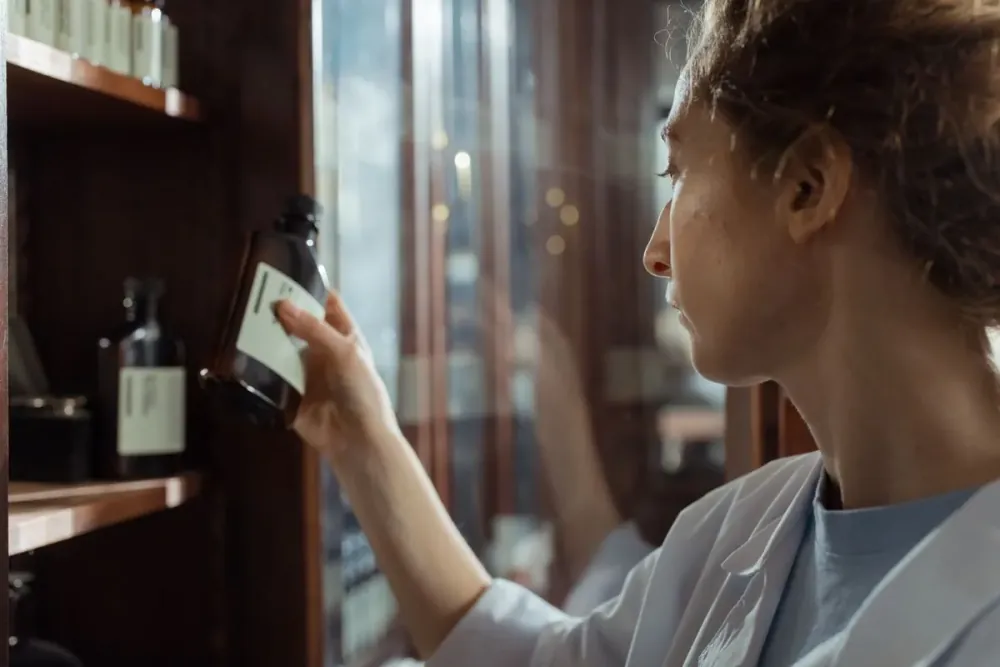 A pharmacist selecting medication from a shelf