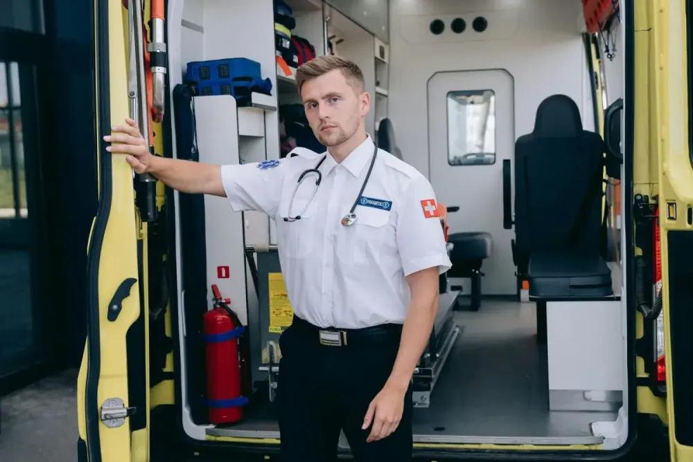 A paramedic standing beside an open ambulance